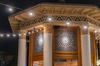 Antik Yunan mimari sütunlarından etkilenen VDNKh Kyiv 'deki çarpıcı tapınak veya pavyon, büyük ahşap kapı üzerindeki ayrıntılı oymalar Kyiv, Ukrayna - 27 Eylül 2025