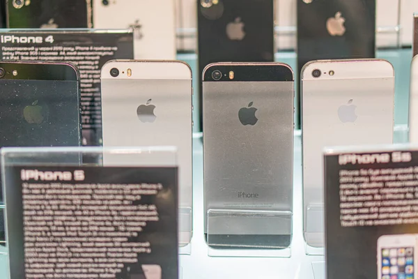 Aydınlatılmış raflarda Apple iPhone 4 'ün aranjmanı, klasik siyah ve gümüş tasarım cihazlarının sergilenmesi, sergi veya Kyiv, Ukrayna - 14 Eylül 2025