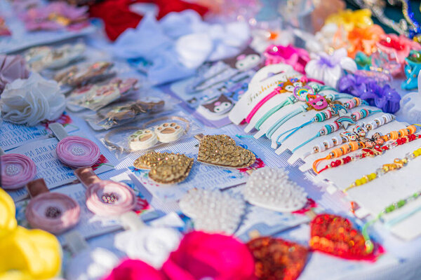 Handcrafted Ukrainian folk jewelry display at a fair, showcasing colorful beads, sequins, metal components, bracelets, necklaces, earrings, arranged on a table under Kyiv, Ukraine - September 20, 2025