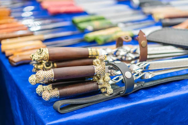 Ukrayna panayırında mavi bir kumaş üzerinde çeşitli bıçaklar bulunan masa, boyut, renk ve tasarım olarak Kyiv, Ukrayna - 25 Eylül 2025