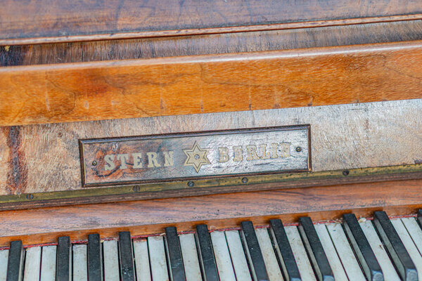 Крупный план старого, темного деревянного фортепиано с изношенными клавишами и металлической арматурой Клавиатура наклонена вниз, показывая различные состояния готовности ударить No text prese Kyiv, Ukraine - September 27, 2025