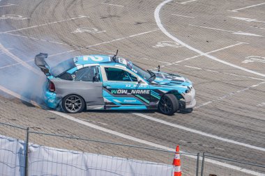 Kyiv Araba Sürükleme Festivali 'nde BMW arabası beyaz çizgiler, doğal ışıklandırma, kuşlar e Kyiv, Ukrayna 06-15-2025 işaretli mavi, beyaz ve siyah çizgili hareket halinde.