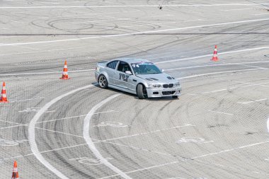 Kyiv Araba Sürükleme Festivali Kyiv, Ukrayna 06-15-2025 'te gümüş BMW pist dönüşü, duman dalgalanması, güvenlik konileri arasında