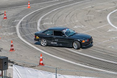 Aerodinamik tasarım, düşük profilli lastikler, beyaz işaretler, turuncu trafik konileri, tel örgüler, gündüz vakti açık gökyüzü, Dyna Kyiv, Ukrayna 06-15-2025