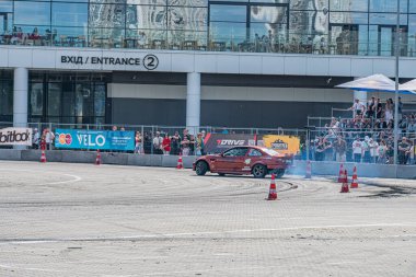 Kırmızı BMW spor arabası Kyiv Araba Sürükleme Festivali 'nin tribünlerinde seyircilerle dolu yüksek hızlı manevra, duman izi, Kyiv, Ukrayna 06-15-2025