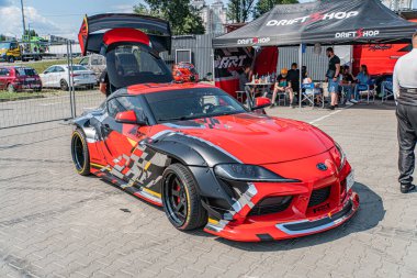 Modifiye edilmiş Toyota Supra Kyiv Araba Sürükleme Festivali Kırmızı ve siyah araba beyaz aksanlı, özel vücut kiti, açık kaput ortaya çıkaran motor Paved sergi alanı, çoklu Kyiv, Ukrayna 06-15-2025