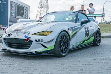 Kyiv Araba Sürükleme Festivali 'nde sokak sahnesi, gündüz saatlerinde 56 numaralı yeşil ve beyaz çizgili Mazda yarış arabası, dinamik düşük açılı Kyiv, Ukrayna 06-15-2025