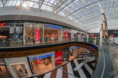 Ukrayna 'nın başkenti Kyiv' deki modern alışveriş merkezinin kendine özgü cam tavanı, merkezi yürüyen merdiven etrafında düzenlenmiş lüks dükkanları var.