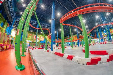 Kyiv Blockbuster Alışveriş Merkezi 'ndeki kapalı lunapark. Renkli roller coaster, yeşil, mavi ve turuncu tonlarıyla baskın, karmaşık kıvrımlar ve tu Kyiv, Ukrayna 06-15-2025