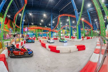 Kyiv Blockbuster Alışveriş Merkezleri, Ukrayna, 06-15-2025 ile eşit ışıklandırılmış kırmızı ve beyaz çizgili bankların serpildiği geniş renkli bir lunapark eğlence parkı.