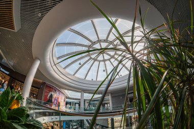 Kyiv Large 'deki modern alışveriş merkezi Blockbuster AVM, dairesel tavan penceresi ve metal çerçeveli açık alan rafları, saksı bitkisi, döşeme döşemesi Kyiv, Ukrayna 06-15-2025