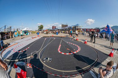 Açık hava Kyiv etkinliği, koniler tarafından işaretlenmiş ve bant ile özetlenmiş eğimli bir pistte uzaktan kumandalı bir araba sürüklenme yarışı içeriyor. İnsanlar izleyici ya da Kyiv, Ukrayna 06-15-2025