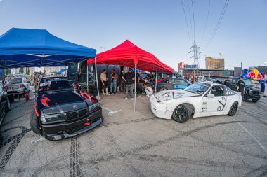 Kyiv 'de düzenlenen araba festivalinde üç eşsiz araba - kırmızı aksanlı siyah, beyaz aksanlı mavi ve siyah aksanlı gümüş - Ukrayna, Kyiv, Ukrayna 06-15-2025 parkında büyük bir kordona alındı