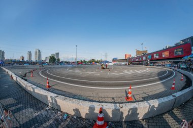 Kyiv Stadyumu veya Arena, Araba Sürükleme Festivali 'ne ev sahipliği yapıyor. Beyaz çizgili yuvarlak hat, kırmızı beyaz trafik konileri yasak bölge, izleyiciler, günlük kıyafetler, gündüz ligi Kyiv, Ukrayna 06-15-2025