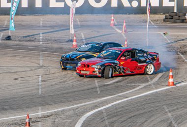 Kyiv Araba Sürükleme Festivali 'ndeki yarış sahnesinde kırmızı, beyaz, güvenlik konileri, asfalt arka plan, gündüz aydınlatma, zıt renk paleti Kyiv, Ukrayna 06-15-2025