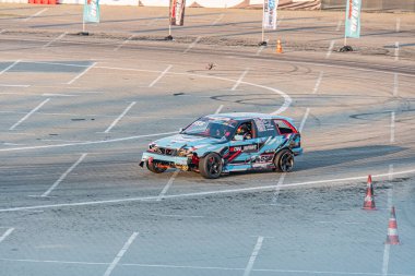 Mavi ve beyaz BMW arabası, siyah ve kırmızı çıkartmalarla süslenmiş, Kyiv Araba Sürükleme Festivali 'nde açık hava pistinde yarışan, Birds' ün gözünün arkasındaki toprak, orangutan Kyiv, Ukrayna 06-15-2025