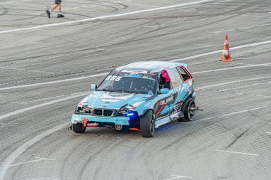 Mavi BMW yarış arabası Kyiv Araba Sürükleme Festivali 'nde gün ışığında aşınmış bir pistte görünür çizikler ve arka kanat Kyiv, Ukrayna 06-15-2025