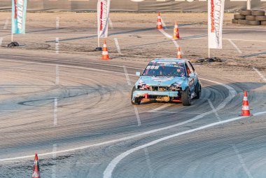 Açık havada sürüklenen hasarlı bir BMW 'nin yüksek açılı çekimi, muhtemelen antrenman sırasında koni ile işaretlenmiş parça, öğleden sonra aydınlatma, beton veya asfalt Kyiv, Ukrayna 06-15-2025