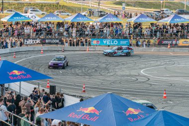 Alacakaranlıkta Kyiv yarış pistinde sürüklenen BMW arabası, markalı Red Bull, Virgin Mobile, pistte yüksek hızlı araba hareketi, Artif Kyiv, Ukrayna 06-15-2025