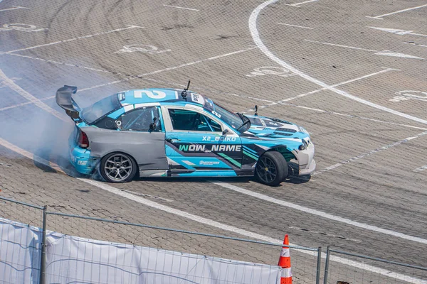 Kyiv Araba Sürükleme Festivali 'nde BMW arabası beyaz çizgiler, doğal ışıklandırma, kuşlar e Kyiv, Ukrayna 06-15-2025 işaretli mavi, beyaz ve siyah çizgili hareket halinde.