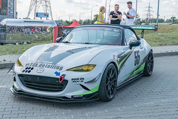 Beyaz spor araba logoları Fender, Electric, Rock Petrol Kyiv Araba Sürükleme Festivali Seyircisi yansıtıcı yelek, kentsel fon, doğal gün ışığı Kyiv, Ukrayna 06-15-2025