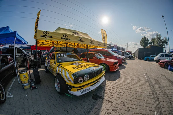 Park yeri geçici bir ralli otomobil galerisine dönüştürüldü, iki parlak renkli BMW arabası, sarı siyah, kırmızı beyaz, yan yana, 23 numaralı promine Kyiv, Ukrayna 06-15-2025