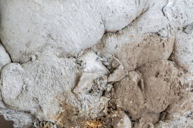 Açığa çıkmış toplam yüzey ile engebeli beton yüzeyin yakın plan fotoğrafı, çeşitli doku ve renkleri göstermektedir. Aydınlatma düzensizlikleri, düzensizlikleri gösterir.