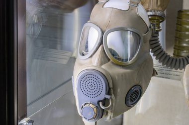 Sergilenen antika gaz maskesi, mat kaplama, cam kutu, çoklu kayışlar, temiz ışıklandırma. a