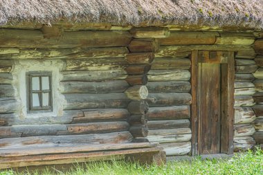 Orta Avrupa 'da eski bir köyde yıpranmış ahşap bir kulübe, birden fazla penceresi, sazdan çatısı ve koyu ahşap kapılı otlak alanı olan merkezi bir pencere yumuşak altında kabini sarar.