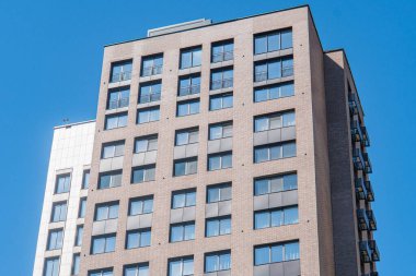 Şehrin modern yüksek binası, dağınık bulutlu mavi gökyüzü, modern mimari tarzı, balkonlar ve pencereler, dikdörtgen şekiller, ızgara deseni, gündüz vakti güneş ışığı yansıması, gölgeler.,