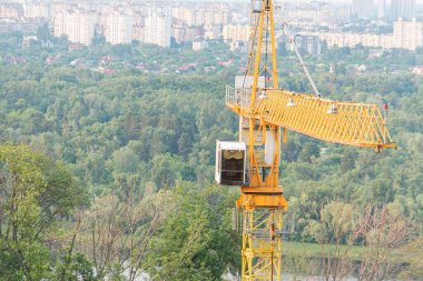 Yüksek bir alanda sarı bir vinç, muhtemelen bir yamaçta, konut yapısına sahip vinç altında birden fazla bölüm, bir taksi, ve uzun flok ışık koşulları erken olduğunu gösteriyor.