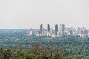 Yumuşak, dağınık ışıklandırma altında sessiz yapılara zıt düşen toprak tonlarının hakim olduğu karışık modern ve tarihsel şehir siluetinin yüksek bakış açısı dikkate değer mimari becerileri de içerir.