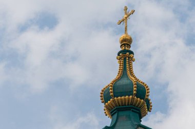 Avrupa 'da eski bir Gotik kilise kulesinin yakın görüntüsü. Altın aksan ve haçlarla süslenmiş üç kubbe ile güneş ışığıyla yıkanmış.