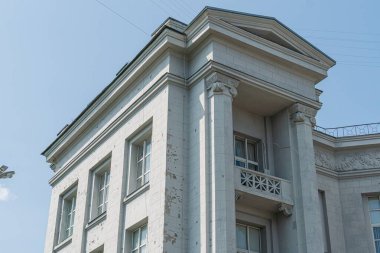 Açık renkli, sütunları, süslemeleri, süslemeleri, çoklu pencereleri, taş çerçeveleri olan klasik şehir binası, açık gökyüzü altında