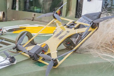 Askeri insansız hava aracı uçak bakımı sahnesinde ele geçirildi, büyük bir askeri helikoptere odaklandı, ağırlıklı olarak yeşil ve gri helikopterler kısmen metalik bir silindir veya