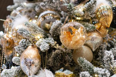 Altın ve gümüş süslemelerle süslenmiş Noel ağacı, tüy ayrıntıları, karımsı elementler, kapalı alanda sıcak ışıklandırma