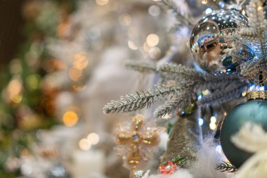 Çeşitli süs ve ışıklarla süslenmiş katmanlı bir Noel ağacına yakın çekim.