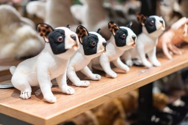 Bir rafta Fransız Bulldog heykelciklerinin gösterimi, yuvarlak yüzler, dik kulaklar, değişik pozlarda beyaz ve siyah kaslı vücutlar ve Kyiv, Ukrayna - 12 Kasım 2025