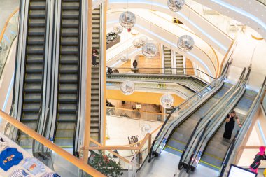 TsUM mağazasındaki Atrium, kıvrımlı duvarları ve dairesel aydınlatma armatürleri olan Kyiv Art Deco binası Tarafsız renk paleti, geniş cilalı fayanslar, yürüyen merdivenler,