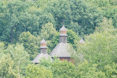 Orta Avrupa 'da yemyeşil bir kır evi, sazdan bir çatı, birden fazla küçük kubbe, doğal taş duvarlar, ağaçlarla çevrili, sabahın erken saatlerinde aydınlatma, sakin bir ortam, ön hazırlık.