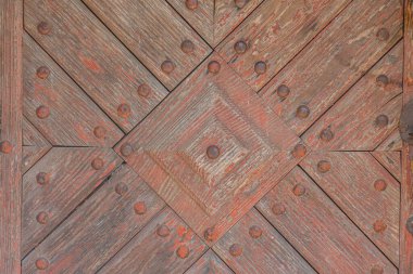 Orta Avrupa 'da doğal ışıklandırması ve zengin, sıcak bir tonu olan, antika, ringa kemiği desenli ahşap bir kapıya yakın plan.