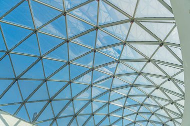 Şehir ortamında cam panelli, geometrik tavanlı modern iç mekan