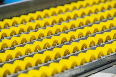 Sanayi deposunun yakın görüntüsü, taşıma bandında sarı elektrik konnektörleri var. Otomatik üretim hattı Metalik bitiş, sıra sıra fabrika arka planında, yapay...