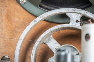 Eski bir metro radyosunun metal mekanik bileşenine yakın çekim, sırtları, birbirine bağlı parçaları, gri tonlu sessiz renkleri, ince dokuları, yumuşak gölgeleri ve gerçek olan dairesel elementler içerir.