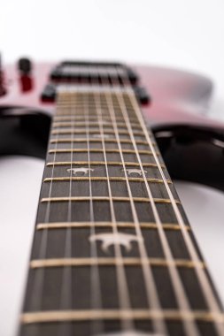 Açılı, dijital olarak değiştirilmiş, koyu renkli gitar yakalı, iki sıra perdeli, hafif ışık kaynaklı yumuşak gölgeler.