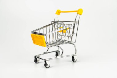 Kırmızı, metalik bir alışveriş arabası beyaz arka planda karşıt sarı gidonu, izole edilmiş, minimalist tasarım satış, ticaret, indirimli konsept çevrimiçi alışveriş ve e-ticaret