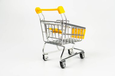 İzole edilmiş kırmızı alışveriş arabası modeli beyaz arka plan minimalist tasarım, siyah metalik bacaklı sarı gövde ve sapları yüksek kontrastlı, yumuşak ışıklandırma perspektifi