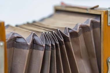 Genişletilmiş körüklü antika kamera lensi, kahverengi renk, eğrilik, mekanik detaylar, profil görünümü