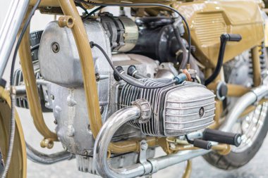 Klasik kahverengi-gümüş-siyah motosiklet, krom parçaları ve cilalanmış metal kaplama, klasik tasarım, sessiz renk paleti, kapalı mekan ayarları, düz dokümantar ile iyi bakımlı motor yan görünümü