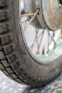 Yıpranmış, eski bir off-road motosiklet tekerleğinin yakın plan görüntüsü bulanık yeşil arka plan, doğal, yumuşak ışıklandırma